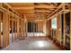 Unfinished living room showing exposed framing, with a window and an electrical outlet visible at 11625 Rolling Springs Dr, Carmel, IN 46033