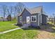 Charming gray home with a well-maintained lawn and inviting walkway leading to the front door at 1217 W 6Th St, Anderson, IN 46016