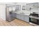 Modern kitchen with gray cabinets, stainless steel appliances, and sleek countertops; wood floors at 1217 W 6Th St, Anderson, IN 46016