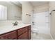 Simple bathroom with a cherry wood vanity, framed mirror and a tub with shower at 1315 Hazy Falls Blvd, Westfield, IN 46074