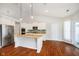 Spacious kitchen with stainless appliances, double oven, granite counters, island with sink, and hardwood floors at 1315 Hazy Falls Blvd, Westfield, IN 46074