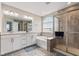 Well-lit bathroom featuring double sinks, a soaking tub, and a separate shower at 1334 Winfield Way, Greenwood, IN 46143