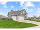 Angle view of an elegant two-story home with a three-car garage and a well-maintained lawn in a residential neighborhood at 1334 Winfield Way, Greenwood, IN 46143