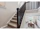 Carpeted staircase with dark wood railing, leading to a dining room filled with sunlight at 1334 Winfield Way, Greenwood, IN 46143