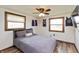 Cozy bedroom featuring wood-trimmed windows, ceiling fan, and hardwood floors at 1502 N Matthews Rd, Greenwood, IN 46143