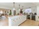 Kitchen island boasts white cabinetry, marble countertops and decorative pendant lighting at 1502 N Matthews Rd, Greenwood, IN 46143