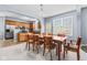 Dining room with a large wooden table and seating for eight, flowing into kitchen and backyard access at 15144 Dry Creek Rd, Noblesville, IN 46060
