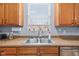 Close up of the kitchen sink features wooden cabinets, stainless steel appliances, and granite countertops at 15144 Dry Creek Rd, Noblesville, IN 46060