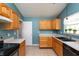 Kitchen with oak cabinets, modern appliances, tile floors, and a view of the backyard through the window at 1579 Winding Creek Trl, Brownsburg, IN 46112