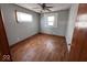 Simple bedroom featuring original hardwood flooring, a ceiling fan, two windows with blinds, and neutral paint at 1618 E 24Th St, Muncie, IN 47302