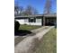 Exterior shot featuring a long gravel driveway leading to a house with an attached carport and partial lawn view at 1618 E 24Th St, Muncie, IN 47302