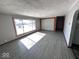 Bright living room featuring wood-look tile, a large picture window, and neutral walls, creating a welcoming space at 1618 E 24Th St, Muncie, IN 47302