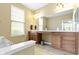 Bathroom featuring dual sinks, a large mirror, neutral paint, and a ceramic tile floor at 16243 Oliver St, Fishers, IN 46037
