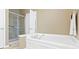 Bright bathroom with separate shower and bathtub, plus neutral walls and ceramic tile flooring at 16243 Oliver St, Fishers, IN 46037