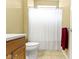 Neutral bathroom featuring a tile floor, wooden cabinet, white toilet, and shower with a white curtain at 16243 Oliver St, Fishers, IN 46037