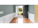 Welcoming foyer with hardwood floors, wainscoting, and an open front door at 16243 Oliver St, Fishers, IN 46037