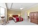 Bright main bedroom boasts a tray ceiling, fan, rocking chair, and ensuite bathroom access at 16243 Oliver St, Fishers, IN 46037
