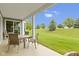 Covered patio with outdoor seating and views of a landscaped lawn and vibrant trees at 16243 Oliver St, Fishers, IN 46037