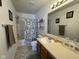 Bathroom featuring a vanity with ample counter space, a large mirror, and a shower-tub combo at 1833 Southernwood Ln, Indianapolis, IN 46231