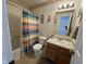 Well-lit bathroom with a combined shower-tub, neutral tiling, and a vanity at 1833 Southernwood Ln, Indianapolis, IN 46231