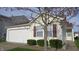Charming home featuring an attached garage, neat shrubbery, and classic neutral siding at 1833 Southernwood Ln, Indianapolis, IN 46231