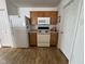A kitchen view featuring a refrigerator, stove, microwave, and wood-look flooring at 1833 Southernwood Ln, Indianapolis, IN 46231
