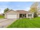 Charming single-story home with manicured lawn, attached garage, and inviting curb appeal at 204 S Hougland St, Trafalgar, IN 46181