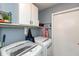 Bright laundry room featuring white cabinets, a utility sink, and modern washer/dryer at 204 S Hougland St, Trafalgar, IN 46181
