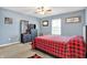 Bedroom showcases a red and black plaid bedspread, accent wall decor, and a dresser with TV at 209 Allen Ln, New Whiteland, IN 46184