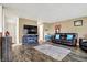 Open-concept living room with dark wood floors, entertainment center, and view into kitchen at 209 Allen Ln, New Whiteland, IN 46184