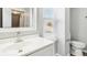 Bright bathroom features a white vanity and toilet along with a mirror and window at 2114 N Dexter St, Indianapolis, IN 46202