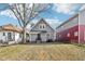 Charming home with gray siding, black door, and well-maintained lawn, nestled between neighboring houses at 2114 N Dexter St, Indianapolis, IN 46202