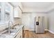 Bright kitchen featuring stainless steel refrigerator, cabinets, countertops, and hardwood floors at 2114 N Dexter St, Indianapolis, IN 46202