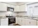 Well-equipped kitchen with stainless steel oven, microwave, white cabinets, and granite countertops at 2114 N Dexter St, Indianapolis, IN 46202