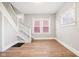 Bright living room featuring hardwood floors and staircase, illuminated by natural light from large windows at 2114 N Dexter St, Indianapolis, IN 46202
