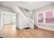 Inviting living room with hardwood floors, showcasing a staircase and open doorway to the front entrance at 2114 N Dexter St, Indianapolis, IN 46202