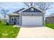 Charming single-story home featuring a two-car garage, landscaped front yard, and inviting hammock at 2239 E Werges Ave, Indianapolis, IN 46237