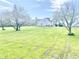 Expansive backyard with a lush lawn, flowering trees, and a view of the home's exterior at 2303 Cole Wood Ct, Indianapolis, IN 46239