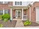 Charming front porch with brick columns, a decorative wreath, and a welcoming seating area and landscaping at 2303 Cole Wood Ct, Indianapolis, IN 46239