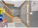 Charming hallway with light gray walls, tile flooring, and a natural wood staircase. Accented with flower arrangement at 2303 Cole Wood Ct, Indianapolis, IN 46239