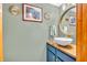 Stylish powder room featuring blue vanity, vessel sink, modern fixtures, and decorative mirror at 2303 Cole Wood Ct, Indianapolis, IN 46239