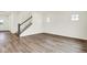 Open-concept living room features wood-look floors, a staircase, and lots of natural light at 2764 Glade Ave, Plainfield, IN 46168