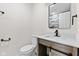 Updated bathroom with modern fixtures, quartz countertop and wood-look vanity with a sliding barn door at 2815 Kay Ellen Dr, Indianapolis, IN 46229