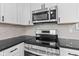 Updated kitchen featuring stainless steel appliances, granite countertops, and white cabinetry for a modern aesthetic at 2815 Kay Ellen Dr, Indianapolis, IN 46229