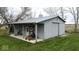 Large gray barn featuring a metal roof, sliding door, concrete pad and an attached covered area for equipment storage at 3335 W 400 N, Anderson, IN 46011