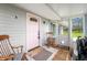 Inviting front porch with rocking chairs and a charming pink front door at 3335 W 400 N, Anderson, IN 46011