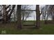 Rustic tree swing hanging between two large trees, offering a charming and relaxing outdoor feature at 3335 W 400 N, Anderson, IN 46011