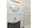 Bathroom featuring a vanity with sink, round mirror, and walk-in shower with built-in shelves at 3516 N Capitol Ave, Indianapolis, IN 46208
