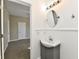 Bathroom featuring a sink with vanity, round mirror, wainscotting, and bedroom view at 3516 N Capitol Ave, Indianapolis, IN 46208