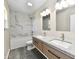 Modern bathroom featuring a double sink vanity, marble tile, and shower-tub combination at 3516 N Capitol Ave, Indianapolis, IN 46208